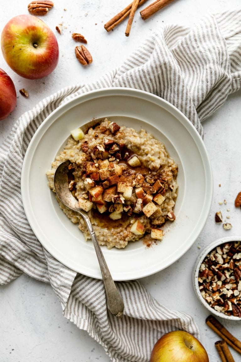 Overhead view of a bowl of Instant Pot Apple Cinnamon Oatmeal topped with pumpkin seeds and pecans. 